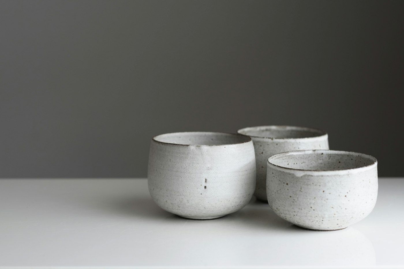 Drie witte keramieken kopjes op een tafel